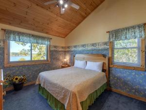 una camera da letto con un letto e due finestre di BEST VIEWS LAKE FRONT Waters Edge a Dandridge