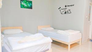 Postel nebo postele na pokoji v ubytování บ้านไม้หอมบูติค สวนผึ้ง