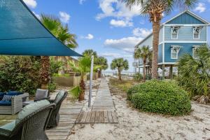 a house on the beach with chairs and an umbrella at Stay Exceptional - 3B Beach Home in Pensacola Beach