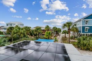 a view of a patio with palm trees and houses at Stay Exceptional - 3B Beach Home in Pensacola Beach