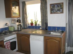 eine kleine Küche mit Spüle und Fenster in der Unterkunft Cosy character cottage conservation area in St Albans