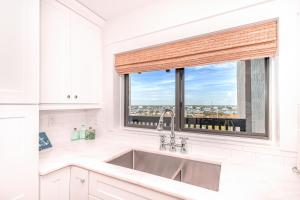 une cuisine blanche avec un évier et une fenêtre dans l'établissement Shipwatch 2B Gulf Front Condo - D603, à Perdido Key 34 autres photos