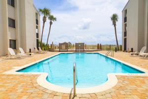 - une piscine au milieu d'un immeuble avec des palmiers dans l'établissement Shipwatch 2B Gulf Front Condo - D603, à Perdido Key