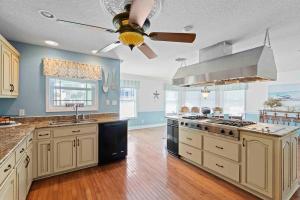 a large kitchen with white cabinets and a ceiling fan at Sea Breeze - 5B Beach Home in Pensacola Beach