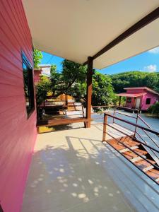 a porch of a house with a pink wall at ตาแอกะยายแดงโฮมสเตย์ in Ban Hong Khu +35 photos