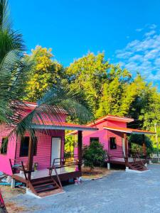 a pink house with a red roof at ตาแอกะยายแดงโฮมสเตย์ in Ban Hong Khu