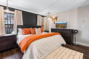 a bedroom with a large bed with an orange blanket at Dolly's Outdoor Oasis in Sevierville
