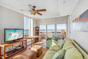 un salon avec un canapé et une télévision à écran plat dans l'établissement Beach Club Gulf Front 4B Condo - 1106, à Pensacola Beach