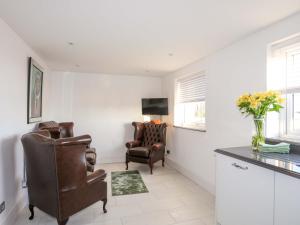a living room with two chairs and a television at Ty'n Ffridd Bach in Pwllheli