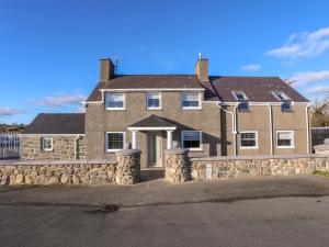 una gran casa de ladrillo con una pared de piedra en Ty'n Ffridd Bach, en Pwllheli
