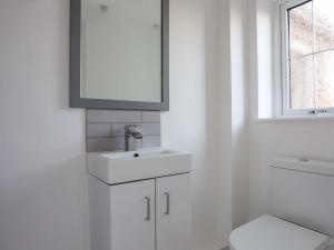 Un baño blanco con lavabo e inodoro. en Ty'n Ffridd Bach, en Pwllheli 18 fotos más