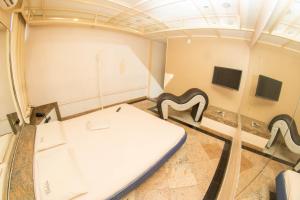 a room with a bed and two paintings on the wall at Motel Calèche in Duque de Caxias