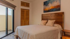 クルス・デ・ウアナカストレにあるCasa Azulのベッドと壁に絵が飾られた寝室