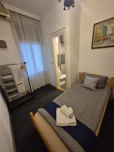 una camera da letto con un letto con due asciugamani sopra di Authentic Belgrade Centre Hostel - Only Private Rooms, Paid Parking on-site, Mandatory Reservation a Belgrado