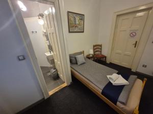 una piccola stanza con un letto e uno specchio di Authentic Belgrade Centre Hostel - Only Private Rooms, Paid Parking on-site, Mandatory Reservation a Belgrado Altre 21 foto