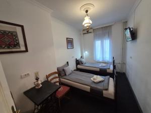 una piccola stanza con due letti e un tavolo di Authentic Belgrade Centre Hostel - Only Private Rooms, Paid Parking on-site, Mandatory Reservation a Belgrado
