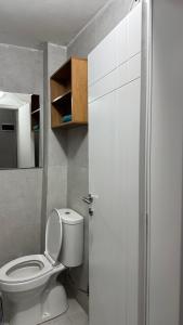 a bathroom with a white toilet and a mirror at Sark in Lezhë