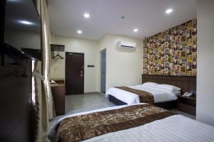a hotel room with two beds and a wall at Island Guesthouse - Previously known as Islander Lodge in George Town