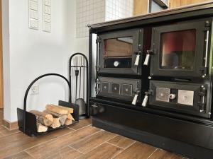 a black oven with a pile of logs in a room at Villa TheView in Bodensdorf