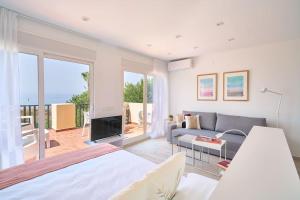 a living room with a bed and a couch at OleHolidays 821 Romana Playa frente al mar in Marbella +18 photos