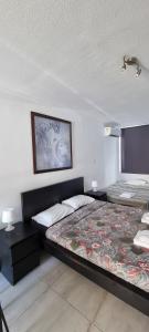 a bedroom with two beds and a picture on the wall at Sea Anemone Apartments in Paphos City