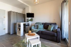 La plage Wifi Climatisation Terrasse Parking Proche mer et commerces في فالراس بلاج: غرفة معيشة بها أريكة وطاولة