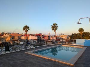 a swimming pool with a view of a city at Hôtel Les Remparts in Azemmour