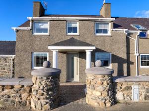 a house with two stone pillars in front of it at Ty'n Ffridd in Pwllheli
