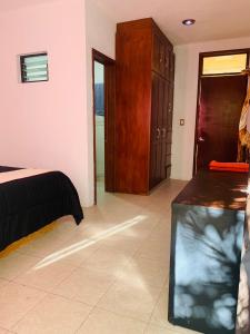 - une chambre avec un lit et des placards en bois dans l'établissement Geranios, à Oaxaca