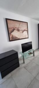 a living room with a couch and a tv on a wall at Sea Anemone Apartments in Paphos City