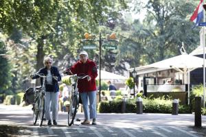 two people standing with their bikes on a street at Herberg Restaurant 't Zwaantje in Mook