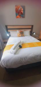 a bedroom with a large bed with white sheets at Isibaya House in Johannesburg