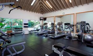 un gimnasio con cintas de correr y máquinas elípticas en The Cove Suites at Blue Waters, en Saint Johnʼs