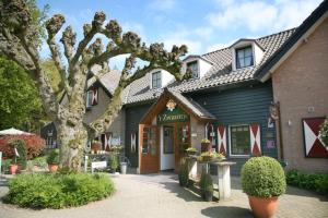 a building with a tree in front of it at Herberg Restaurant 't Zwaantje in Mook
