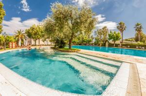 a swimming pool with a tree in the middle at Villa Irlanda Grand Hotel in Gaeta