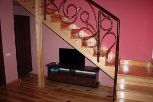 a living room with a staircase with a tv at Troyanda in Radyvyliv