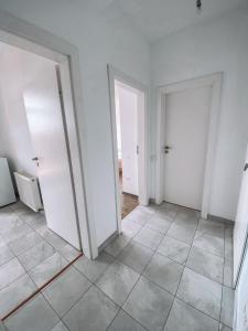 an empty room with two doors and a tile floor at Mountain View Apartment in Sibiu