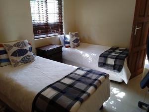 a bedroom with two beds and a window at Aloha Lodge 2 Bedroom Apartment near Menlyn Sleeps 4 in Pretoria