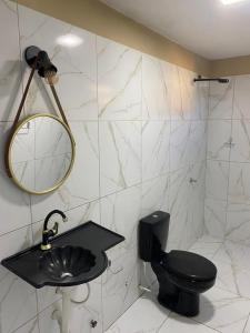 a bathroom with a black toilet and a sink at Portal do Sol in Canoa Quebrada +34 photos