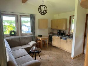 BehrensdorfにあるFerienhaus 2 Campingpark Waldesruhのソファとキッチンのあるリビングルーム