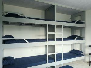 a bunk bed with three bunk beds in a room at Guará Apart 3 in Guaratuba