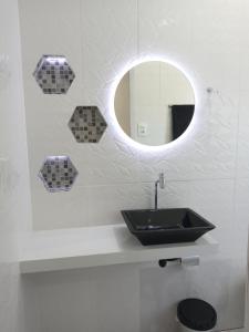 a bathroom with a black sink and a mirror at Guará Apart 3 in Guaratuba