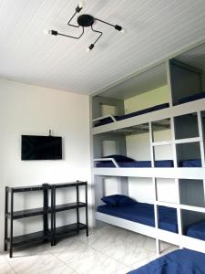 two bunk beds in a room with a tv at Guará Apart 3 in Guaratuba