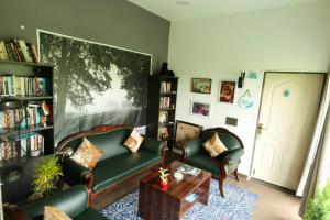 a living room with a couch and chairs and a book shelf at Jewel Stay in Tāla
