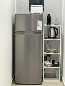 a stainless steel refrigerator in a kitchen next to a shelf at Mirea Guest House in Latina