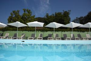 a group of chairs and umbrellas next to a swimming pool at Villa Gradoni in Monticelli Brusati