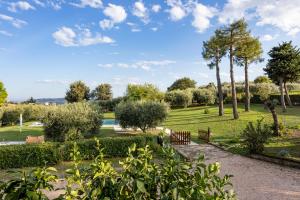 a park with a bench and trees and a pond at Casal La Ponderosa in SantʼElpidio a Mare
