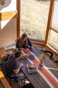 a man and a woman playing a game at a picnic table at Fairplay Coyote Cabin in Fairplay