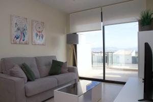un salon avec un canapé et une grande fenêtre dans l'établissement Precioso apartamento con piscina y jacuzzi R100 by Novadesta, à Puerto Marino