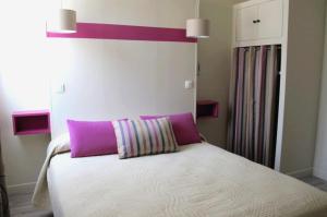 a bed with a purple pillow on top of it at Hotel Le Havre Bleu in Beaulieu-sur-Mer